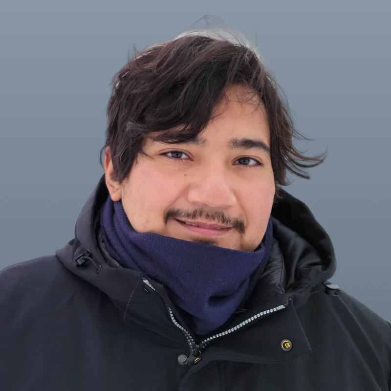 Carlos A. Perez-Herrera, head and shoulders, on a plain blue-grey background.